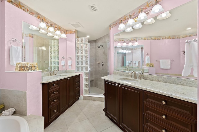 full bathroom featuring two vanities, a sink, visible vents, a shower stall, and tile patterned floors