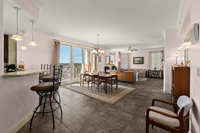 dining space featuring baseboards, ceiling fan with notable chandelier, and crown molding