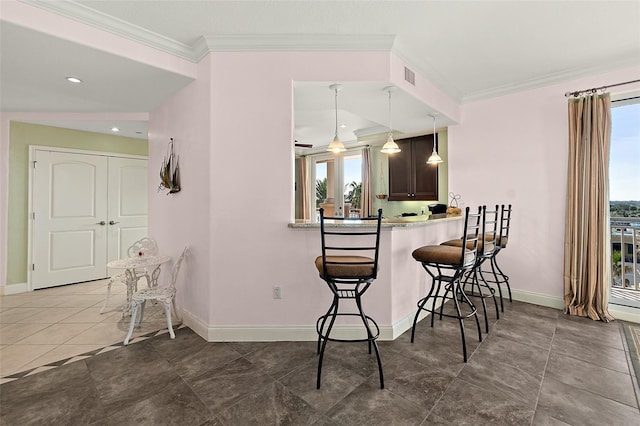 kitchen with visible vents, hanging light fixtures, ornamental molding, a peninsula, and a kitchen breakfast bar