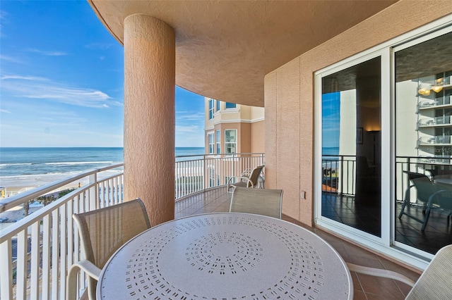 balcony featuring a water view and a view of the beach