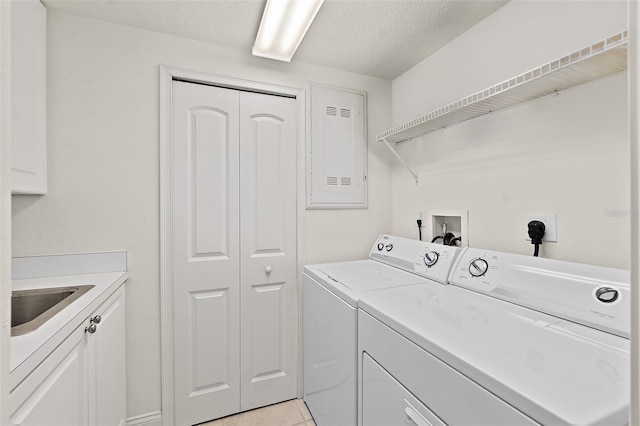 washroom featuring a textured ceiling, independent washer and dryer, a sink, and cabinet space