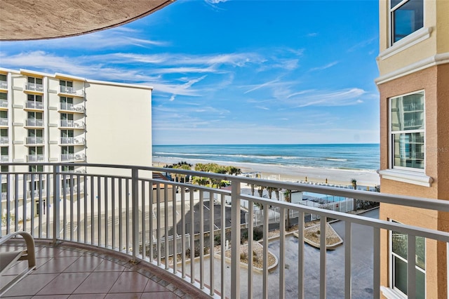 balcony with a water view and a view of the beach