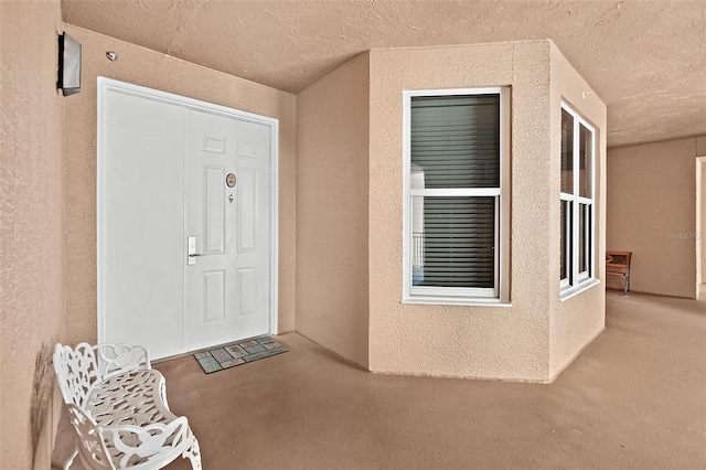 doorway to property featuring a patio area and stucco siding