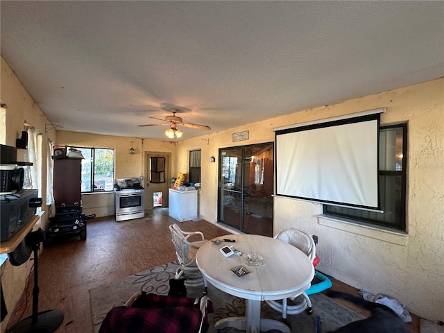 dining area featuring a ceiling fan, wood finished floors, a textured ceiling, and a textured wall