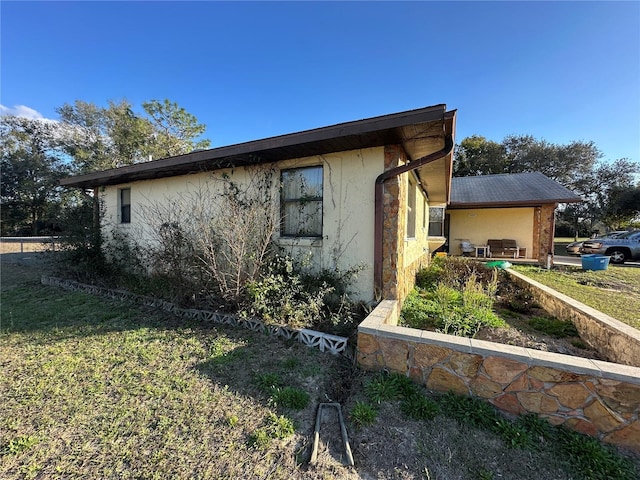 view of property exterior with a lawn and stucco siding