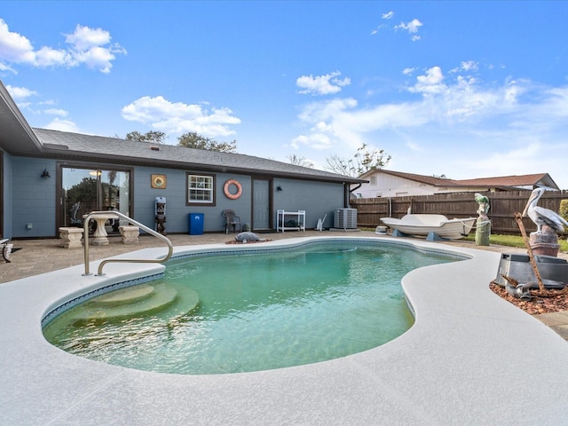 view of swimming pool with a fenced in pool, fence, central AC unit, and a patio area