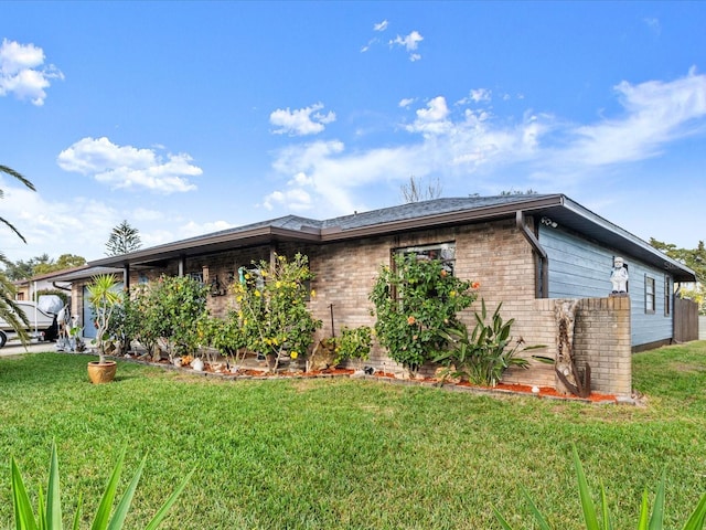 view of side of home with a yard and brick siding