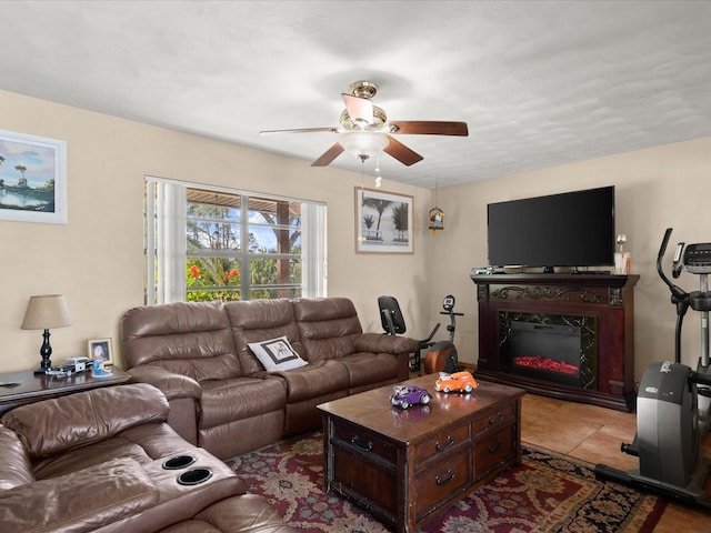 living area featuring light tile patterned floors, ceiling fan, and a high end fireplace