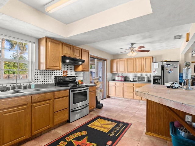 kitchen with visible vents, backsplash, under cabinet range hood, stainless steel appliances, and a sink