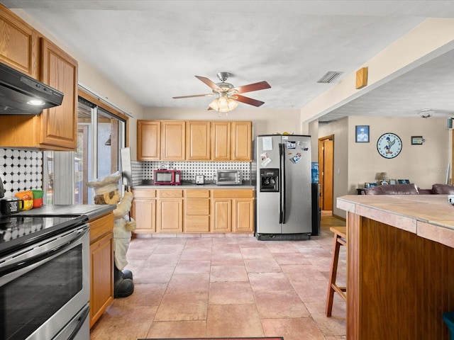 kitchen with visible vents, ceiling fan, under cabinet range hood, decorative backsplash, and stainless steel appliances