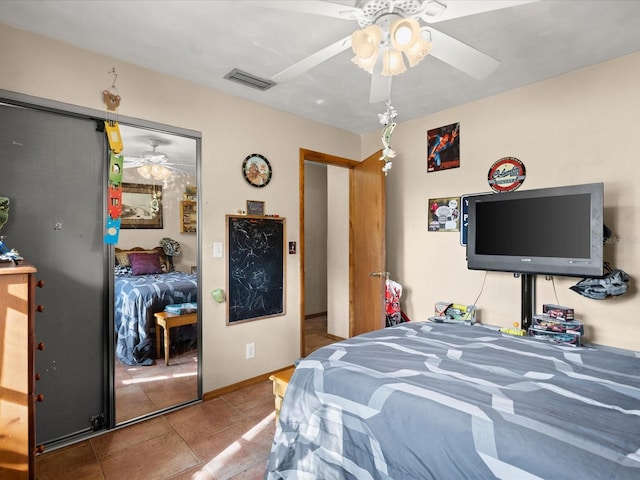 tiled bedroom with visible vents, ceiling fan, and baseboards