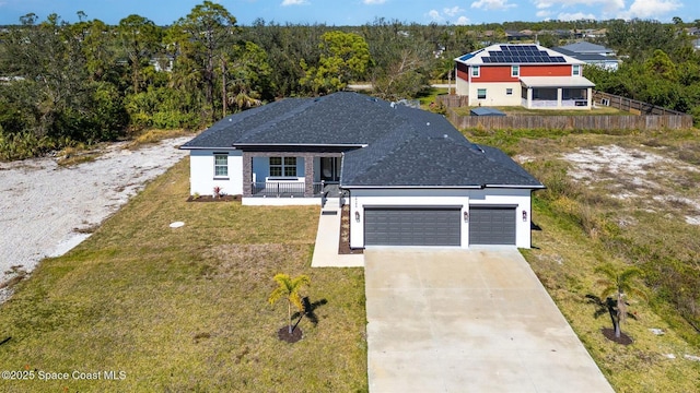 view of front of property with a shingled roof, concrete driveway, an attached garage, a front yard, and fence