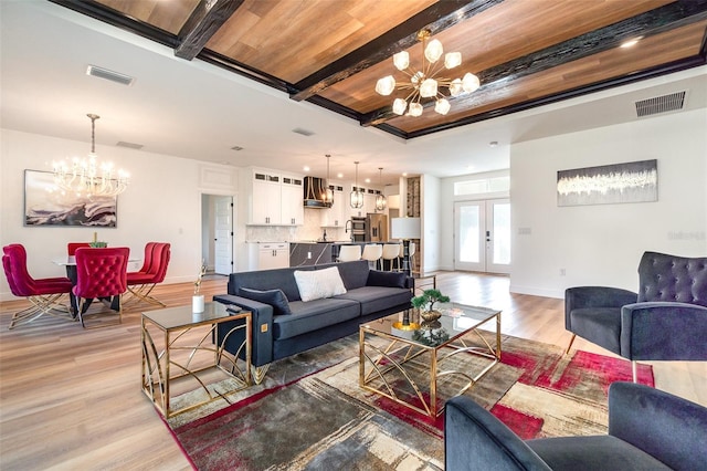 living area with light wood finished floors, visible vents, beamed ceiling, an inviting chandelier, and french doors