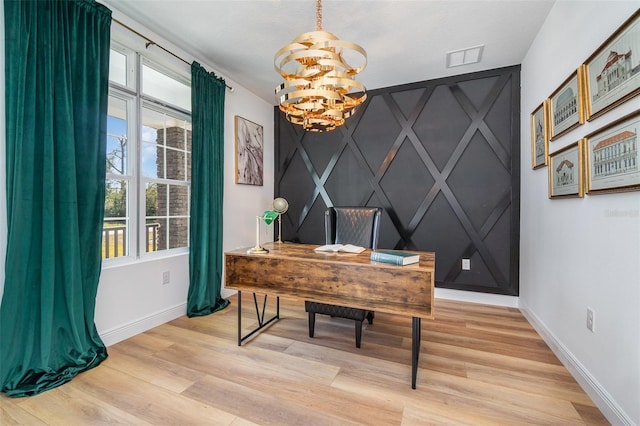 office area with an inviting chandelier, light wood-style flooring, an accent wall, and baseboards