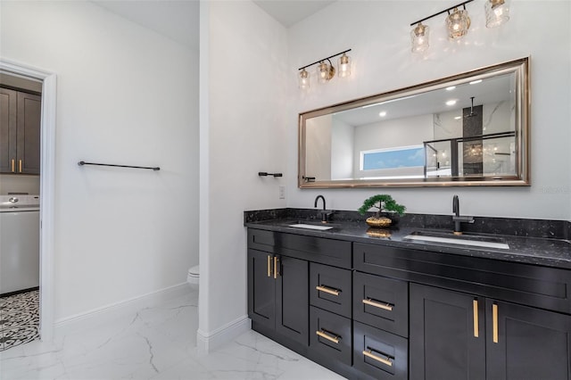 bathroom with washer / clothes dryer, a sink, marble finish floor, and baseboards