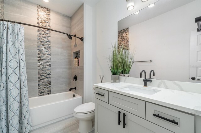 bathroom with shower / tub combo with curtain, vanity, and toilet