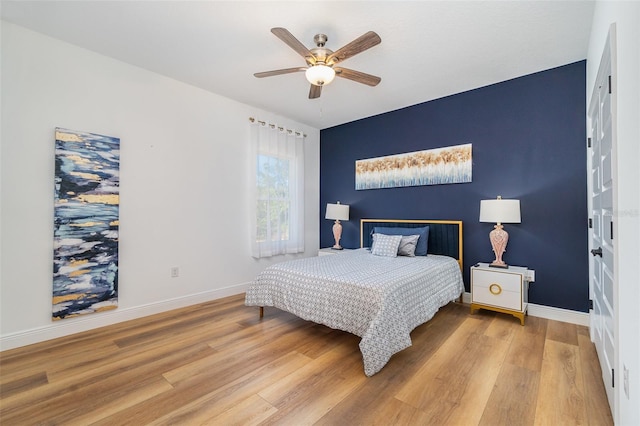 bedroom with ceiling fan, wood finished floors, and baseboards