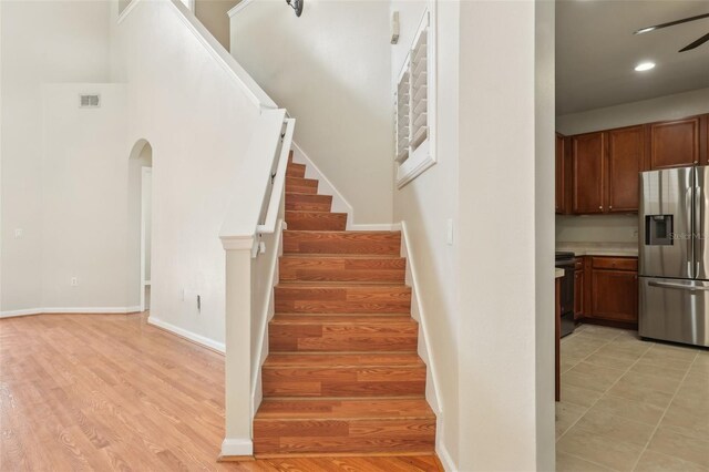 3691 Titanic Cir, Melbourne, FL 32903 - stairway featuring arched walkways, a ceiling fan, baseboards, wood finished floors, and recessed lighting
