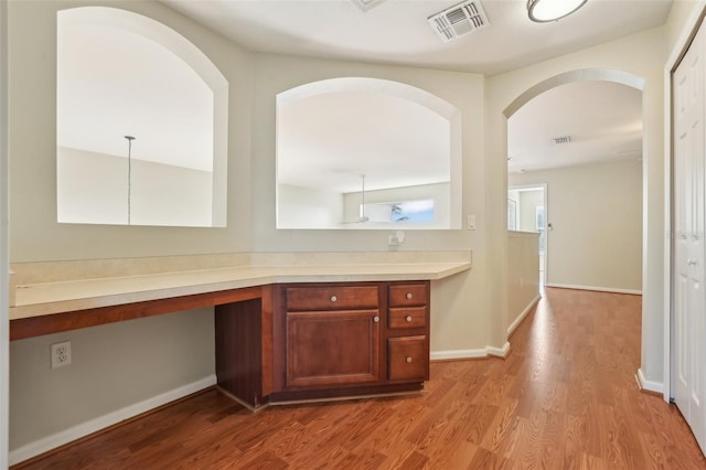 3691 Titanic Cir, Melbourne, FL 32903 - kitchen with wood finished floors, light countertops, baseboards, and an office area