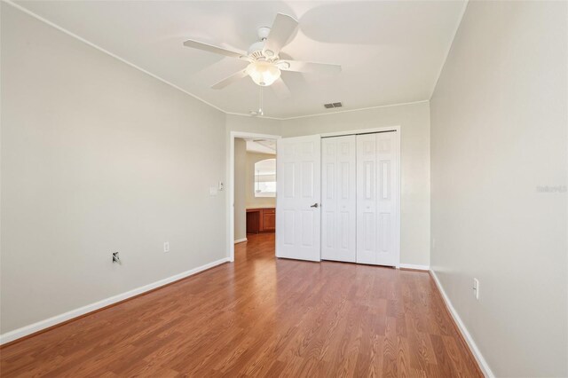 3691 Titanic Cir, Melbourne, FL 32903 - unfurnished bedroom with wood finished floors, baseboards, a closet, and a ceiling fan
