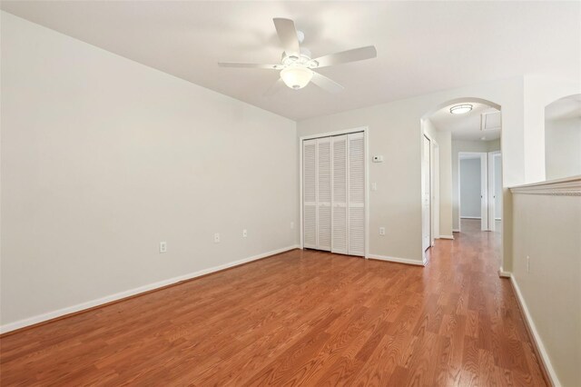 3691 Titanic Cir, Melbourne, FL 32903 - unfurnished bedroom featuring wood finished floors, baseboards, arched walkways, ceiling fan, and a closet