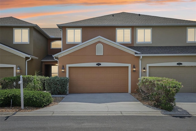 3691 Titanic Cir, Melbourne, FL 32903 - townhome / multi-family property with stucco siding, a garage, concrete driveway, and roof with shingles