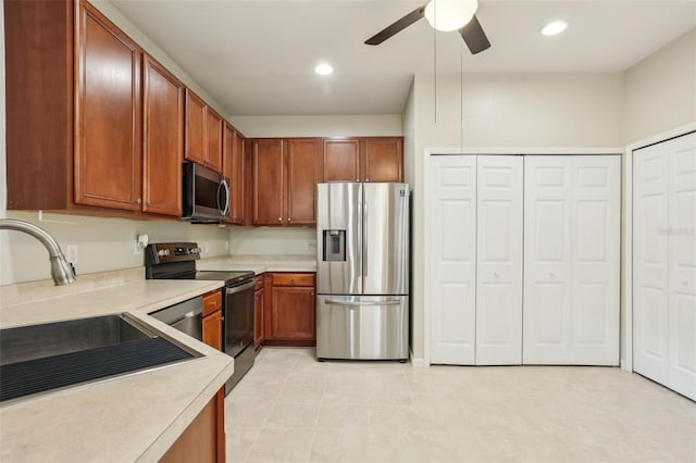 3691 Titanic Cir, Melbourne, FL 32903 - kitchen with appliances with stainless steel finishes, light countertops, ceiling fan, a sink, and brown cabinetry