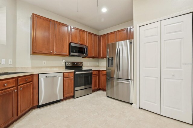 3691 Titanic Cir, Melbourne, FL 32903 - kitchen featuring stainless steel appliances, light countertops, brown cabinetry, and recessed lighting