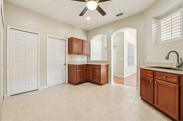 3691 Titanic Cir, Melbourne, FL 32903 - kitchen featuring ceiling fan, light countertops, arched walkways, a sink, and baseboards
