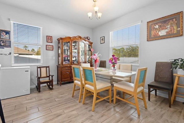 dining area with an inviting chandelier, baseboards, and wood finish floors