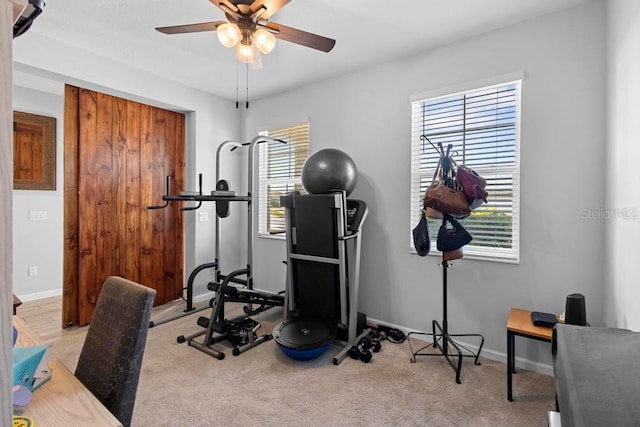 exercise room with carpet floors, baseboards, and a ceiling fan