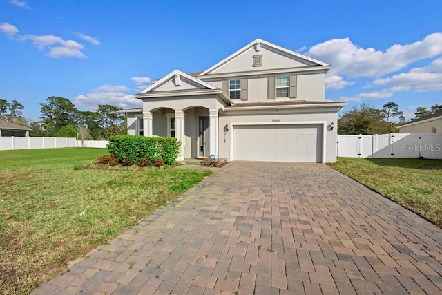 traditional home with a front yard, decorative driveway, fence, and a gate