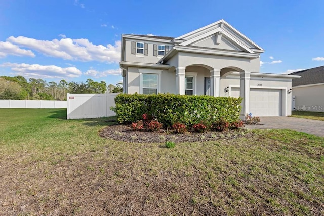 view of front facade with an attached garage, fence, decorative driveway, a front yard, and stucco siding