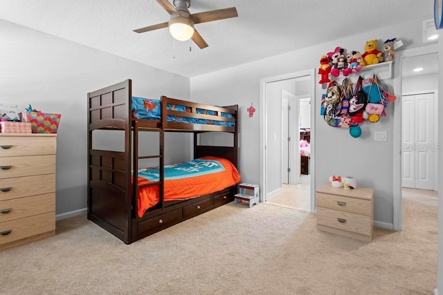 carpeted bedroom featuring visible vents, ceiling fan, a textured ceiling, and baseboards