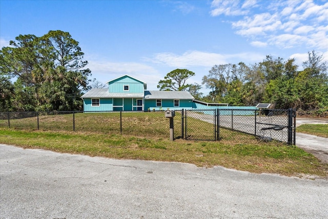 view of front of house featuring a fenced front yard, a front yard, concrete driveway, and a gate