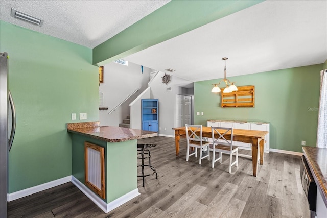 kitchen featuring baseboards, visible vents, and wood finished floors