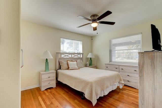 bedroom featuring wood finished floors, baseboards, and ceiling fan