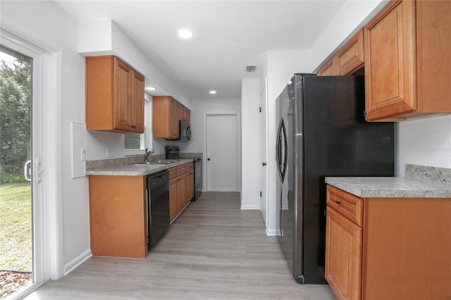 kitchen featuring black appliances, plenty of natural light, visible vents, and a sink