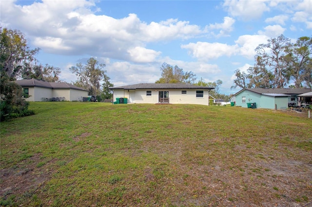 rear view of house featuring a yard