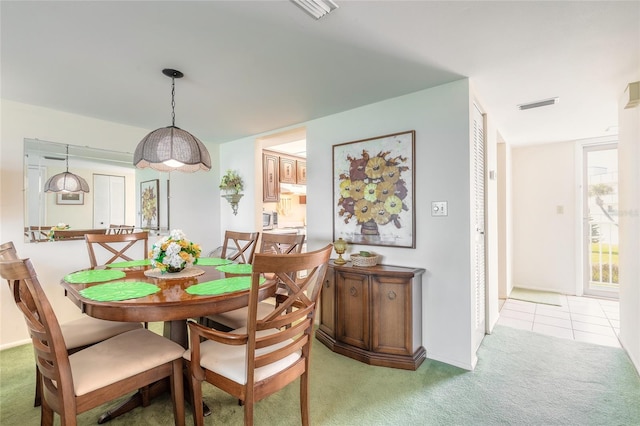 dining space with light tile patterned floors, visible vents, and light colored carpet