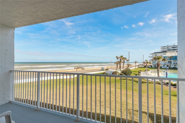 balcony featuring a water view and a beach view