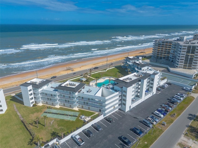 birds eye view of property with a water view and a beach view