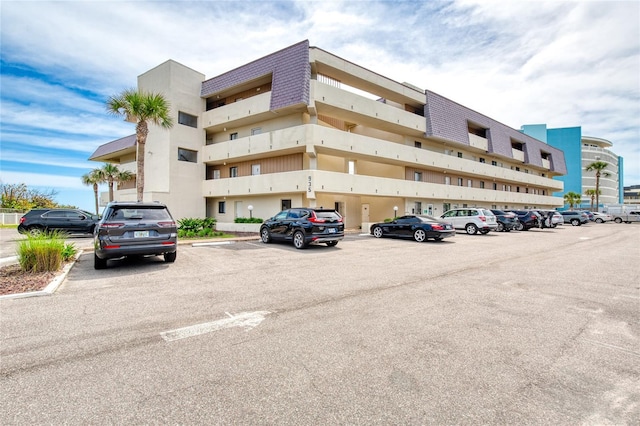 view of building exterior with uncovered parking