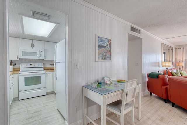 kitchen featuring light countertops, white appliances, white cabinets, and visible vents