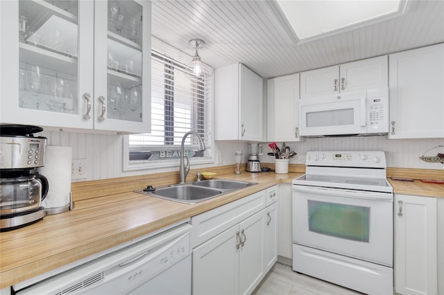 kitchen with light countertops, white appliances, a sink, and white cabinets