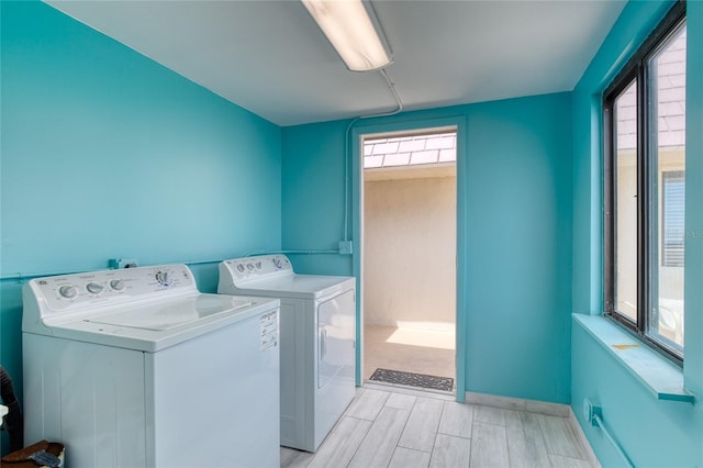 laundry area featuring wood finish floors, laundry area, baseboards, and separate washer and dryer