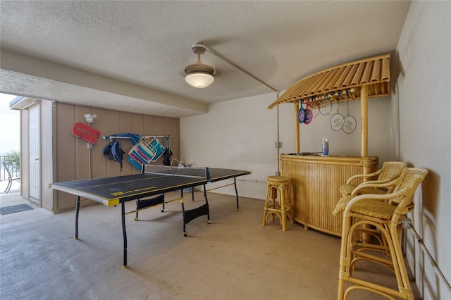 recreation room with a textured ceiling