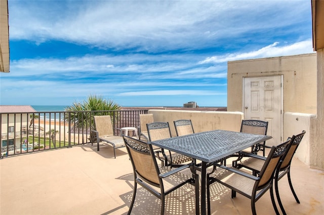 view of patio / terrace with a balcony, a water view, and outdoor dining area