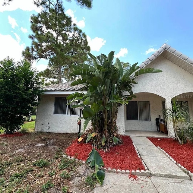 view of front of property with a tiled roof and stucco siding