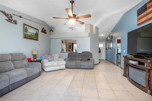 living room with lofted ceiling, a ceiling fan, a textured ceiling, and light tile patterned flooring